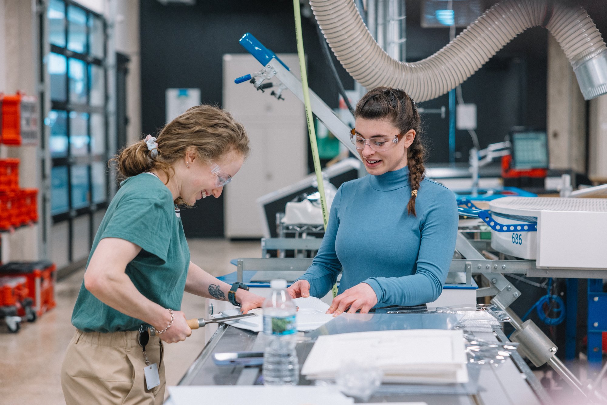 two women work by the laser cutters at the mHUB Innovation Center