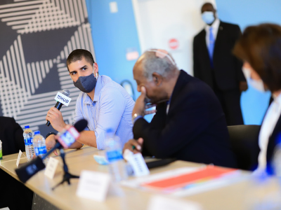 Man holding microphone at roundtable discussion